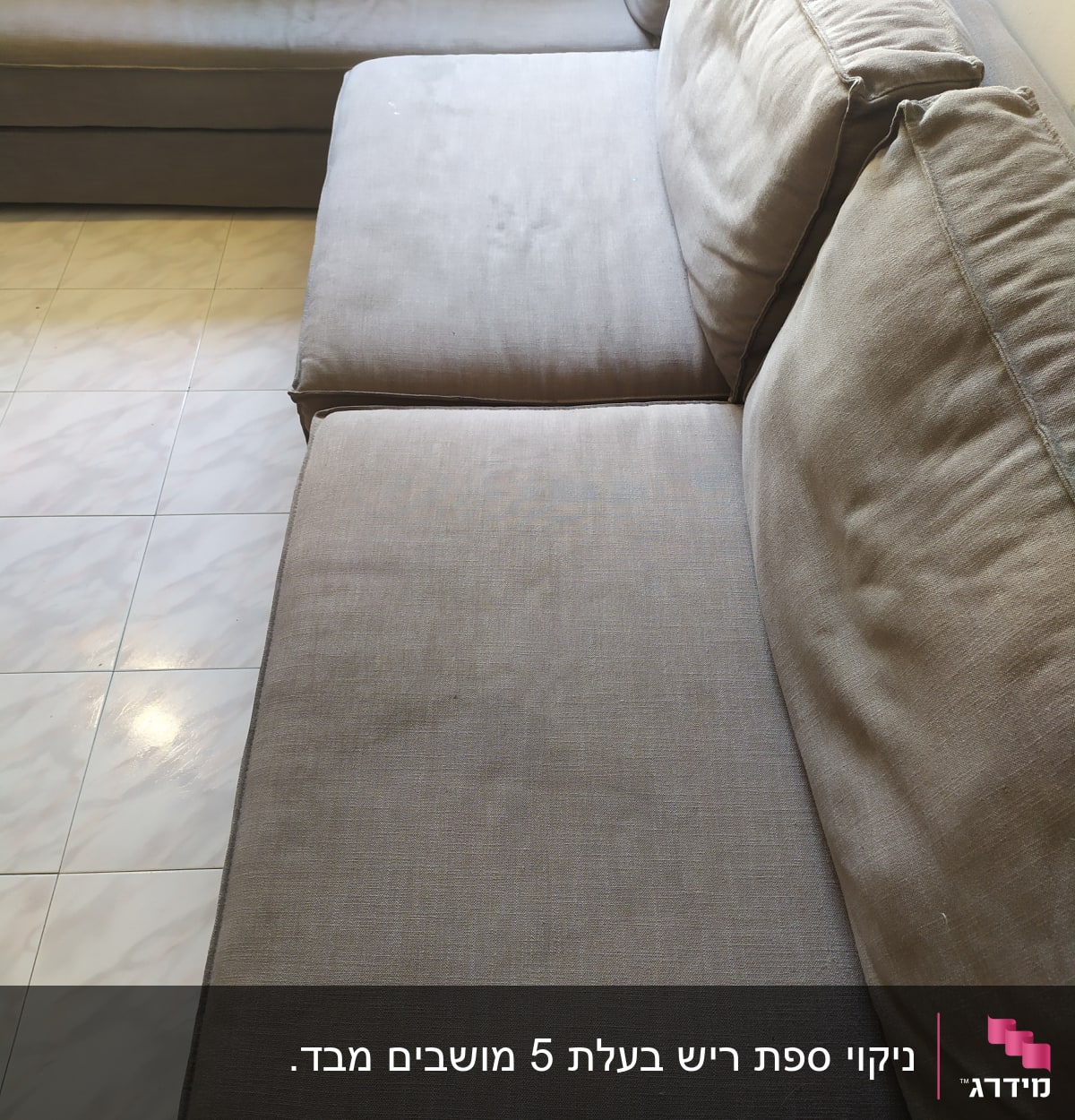 ספה אפורה עם כריות על רצפת אריחים